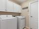 Bright laundry room features a white washer, dryer, and storage cabinets for a clean and organized space at 8251 Arlewood Cir, Port Charlotte, FL 33981
