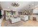Bright living room with a large sectional sofa, tile flooring and a unique ceiling fan at 8251 Arlewood Cir, Port Charlotte, FL 33981