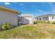 A single story metal utility storage shed in backyard with white roll-up door and wood deck at 8251 Arlewood Cir, Port Charlotte, FL 33981