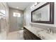 Modern bathroom featuring dual sinks, granite countertops, a tiled shower, and a decorative mirror at 8304 Antwerp Cir, Port Charlotte, FL 33981