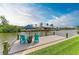 Tranquil scene of the waterfront dock with cozy blue chairs, an umbrella, and scenic views of the water at 8304 Antwerp Cir, Port Charlotte, FL 33981
