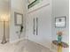 Foyer featuring a high ceiling, neutral color scheme, tiled flooring, and modern lighting fixtures, creating a bright and inviting space at 8304 Antwerp Cir, Port Charlotte, FL 33981