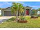 Charming single-story home showcasing a well-manicured lawn, garden, and a two-car garage at 8304 Antwerp Cir, Port Charlotte, FL 33981