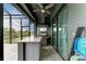 View of the outdoor kitchen featuring a stainless steel grill, modern countertop, and a ceiling fan at 8304 Antwerp Cir, Port Charlotte, FL 33981
