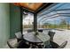 Covered patio with a round wooden table and seating for six near pool at 8304 Antwerp Cir, Port Charlotte, FL 33981