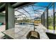 Inviting pool area with a waterfall feature, sun loungers, and a screened enclosure for outdoor enjoyment at 8304 Antwerp Cir, Port Charlotte, FL 33981