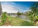 Picturesque waterfront view with a private dock, lush greenery, and calm waters at 8304 Antwerp Cir, Port Charlotte, FL 33981