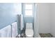 Well-lit bathroom featuring a toilet, a shower with a patterned curtain, and blue textured walls at 840 Park Rd, Englewood, FL 34223