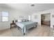 Bright bedroom with light wood floors, leading to an ensuite bathroom and featuring two windows at 840 Park Rd, Englewood, FL 34223