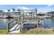 A wooden dock on the canal with a boat lift is perfect for boating and fishing enthusiasts at 840 Park Rd, Englewood, FL 34223