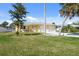 Charming one-story yellow home featuring a well-maintained lawn and driveway at 840 Park Rd, Englewood, FL 34223