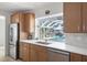 This kitchen features stainless steel appliances, quartz countertops, wood cabinets, and backyard views at 840 Park Rd, Englewood, FL 34223