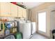 Laundry room with washer, dryer, overhead cabinets and shelving at 840 Park Rd, Englewood, FL 34223
