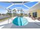 A screened pool with seating, palm trees, and blue skies is great for Gathering gatherings and entertaining guests at 840 Park Rd, Englewood, FL 34223