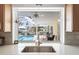 Enjoy backyard views from this sink with stainless steel faucet, white quartz countertops, and stone backsplash at 840 Park Rd, Englewood, FL 34223