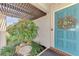 Close up of home entry showcasing the bright turquoise door with a floral wreath and attractive potted plant at 849 Linnaen Nw Ter, Port Charlotte, FL 33948