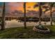 Beautiful canal view with a fountain and palm trees against a backdrop of a vibrant sunset at 9325 Saint Paul Dr, Port Charlotte, FL 33981