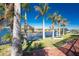 Lush backyard with manicured landscaping, palm trees, and serene waterfront views of the canal at 9325 Saint Paul Dr, Port Charlotte, FL 33981