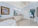 Bathroom with double vanity, soaking tub, decorative tile work, and an entrance to bedroom at 9325 Saint Paul Dr, Port Charlotte, FL 33981