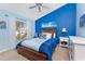 A blue-themed bedroom with a ceiling fan, painting and natural light from the window at 9325 Saint Paul Dr, Port Charlotte, FL 33981