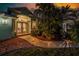 Inviting entryway features a winding walkway, lush landscaping, and bright exterior lights, creating a warm welcome at 9325 Saint Paul Dr, Port Charlotte, FL 33981