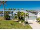 Inviting single Gathering home showcasing a well-manicured lawn, mature palms and a paved driveway leading to a two-car garage at 9325 Saint Paul Dr, Port Charlotte, FL 33981