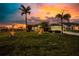 Beautifully landscaped front yard with lush grass, mature palms, and well-placed lighting for enhanced curb appeal at 9325 Saint Paul Dr, Port Charlotte, FL 33981