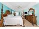 Spacious bedroom featuring a decorative wood bed frame, ceiling fan and light blue walls at 9325 Saint Paul Dr, Port Charlotte, FL 33981