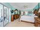 Bright main bedroom featuring a decorative wood bed frame, ceiling fan, and sliding door to patio at 9325 Saint Paul Dr, Port Charlotte, FL 33981