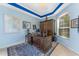 A home office with a large wooden desk and built-in shelving, with cool blue walls at 9325 Saint Paul Dr, Port Charlotte, FL 33981