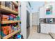 Pantry features custom shelving and storage adjacent to the kitchen and refrigerator at 9325 Saint Paul Dr, Port Charlotte, FL 33981