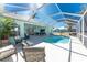 Relaxing screened-in patio with comfortable seating and scenic views of the lush backyard and canal at 9325 Saint Paul Dr, Port Charlotte, FL 33981