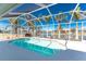 Relaxing screened-in pool with a view of the canal, surrounded by beautiful palm trees and an area for outdoor seating at 9325 Saint Paul Dr, Port Charlotte, FL 33981