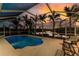 Sparkling pool is surrounded by an enclosed lanai, providing stunning views of the water and tropical palm trees at 9325 Saint Paul Dr, Port Charlotte, FL 33981