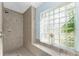 Shower with tile walls, tiled shower floor, a glass block window and a shower head at 9325 Saint Paul Dr, Port Charlotte, FL 33981
