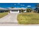Charming home with a well-manicured lawn and a long driveway leading to a two-car garage at 9430 Heartwellville Ave, Englewood, FL 34224