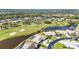 Aerial view of a residential community featuring homes situated on a pond near the golf course at 977 N Doral Ln, Venice, FL 34293