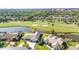 Aerial view of a residential home overlooking a lush golf course and scenic pond at 977 N Doral Ln, Venice, FL 34293