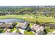 Aerial view of a residential home overlooking a lush golf course and scenic pond at 977 N Doral Ln, Venice, FL 34293