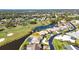 Aerial view of a house featuring a pool, pond, golf course, and road at 977 N Doral Ln, Venice, FL 34293
