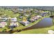 Aerial view of a residential home with a screened pool, situated on a pond near the golf course at 977 N Doral Ln, Venice, FL 34293