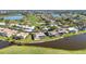 Aerial view of residential homes with pools situated on a pond near the golf course at 977 N Doral Ln, Venice, FL 34293
