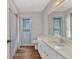 Bright bathroom featuring a vanity with a sink, a large mirror, and direct access to the backyard at 977 N Doral Ln, Venice, FL 34293