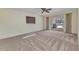 Carpeted bedroom with a ceiling fan, a window with blinds, and sliding glass doors to the pool area at 977 N Doral Ln, Venice, FL 34293