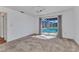 Bright bedroom with carpet and sliding glass doors leading to a screened pool area at 977 N Doral Ln, Venice, FL 34293