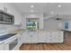Updated kitchen with stainless microwave, white cabinets, modern appliances, wood-look flooring, and a view to the outdoor patio at 977 N Doral Ln, Venice, FL 34293