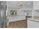 Bright kitchen featuring white cabinetry, modern appliances, wood-look flooring, and lots of natural light at 977 N Doral Ln, Venice, FL 34293