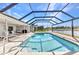 Screened pool area featuring a clear blue pool and view of the water behind the property at 977 N Doral Ln, Venice, FL 34293