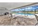 Inviting screened-in lanai with a pool, lounge chairs, and a peaceful view at 977 N Doral Ln, Venice, FL 34293