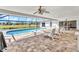 Covered lanai area including screened pool, golf course views, ceiling fans, and dining area at 977 N Doral Ln, Venice, FL 34293